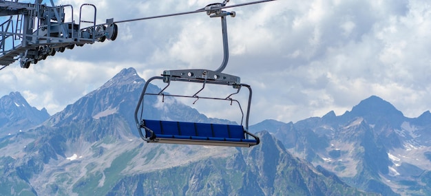 Téléphérique au sommet d'une montagne par temps nuageux Téléphérique moderne avec bancs en terrain montagneux incroyable