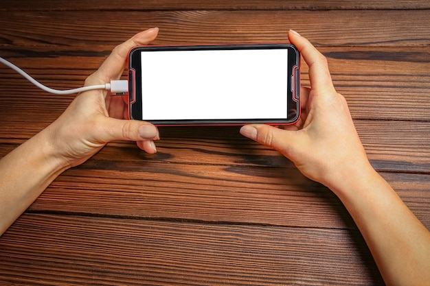 Téléphone avec addiction mains sur une surface en bois