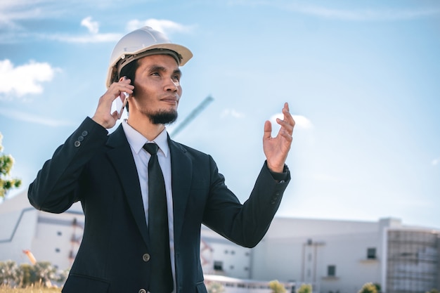 Téléphone d'appel d'affaires travaillant en plein air sur la construction du site