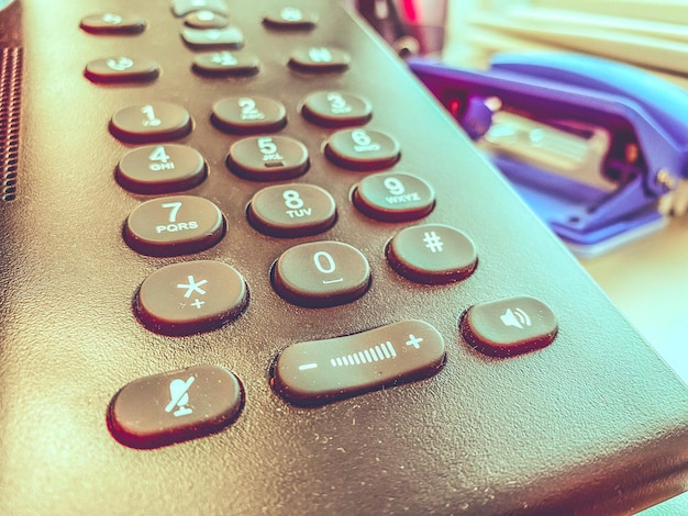 Téléphone de bureau avec de gros boutons sur une table en bois