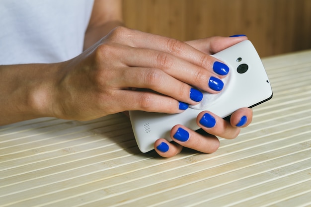 Téléphone cellulaire de la couleur blanche, mains propres