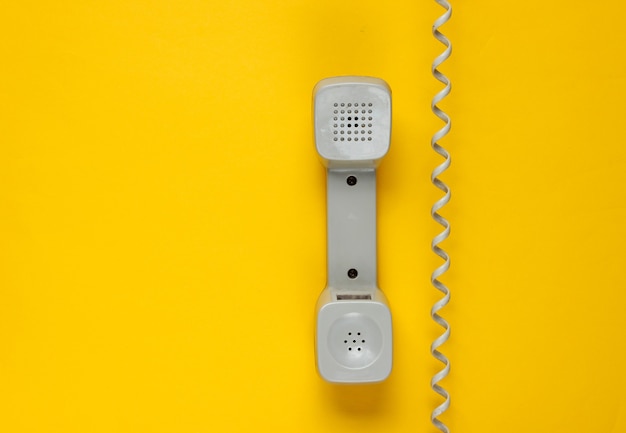 Téléphone combiné rétro avec câble sur jaune