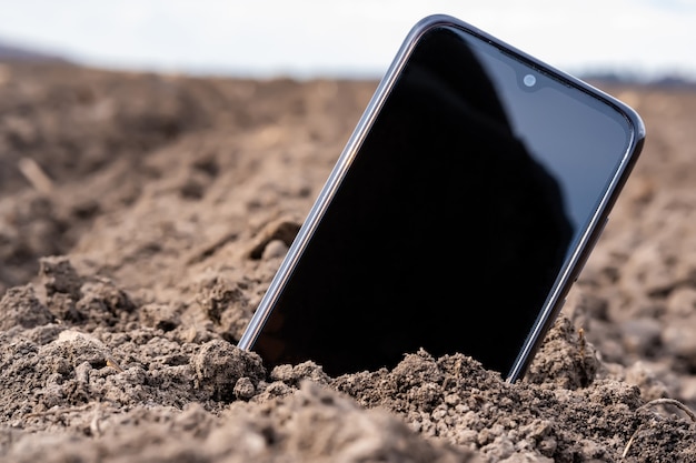 Le téléphone dépasse du sol sur le terrain.