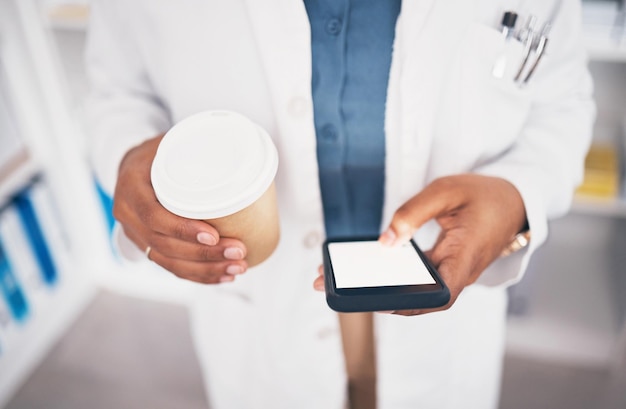 Téléphone du pharmacien ou mains d'une personne avec du café envoyant des SMS à la pharmacie pour contacter un e-mail ou un chat en ligne Espace de maquette de médias sociaux ou médecin sur une application mobile tapant ou recherchant des nouvelles médicales pendant la pause thé