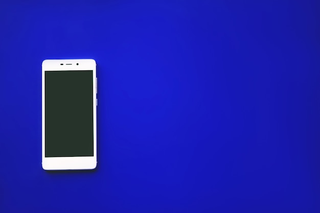 Téléphone à écran tactile moderne sur fond bleu, pour la conception ou la maquette de téléphone portable.