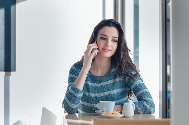 Téléphone de fille appelant au café