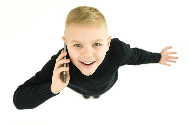 Le téléphone garçon heureux sur fond blanc. Vue d'en-haut