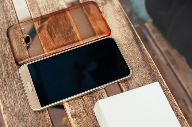 Téléphone intelligent et couvercle sur table en bois, à vendre