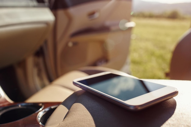 Téléphone intelligent sur le tableau de bord du siège de voiture