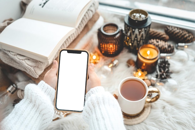 Téléphone en mains avec place isolée pour le texte dans l'ambiance de Noël