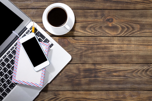 Téléphone avec ordinateur portable et tasse de café