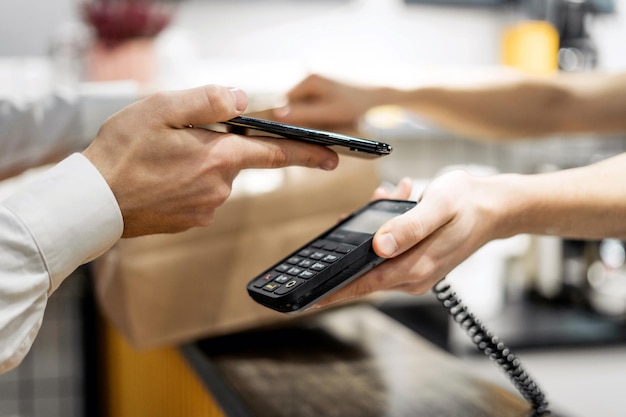 Le téléphone de paiement NFC à côté du terminal paie l'achat dans un café restaurant avec un