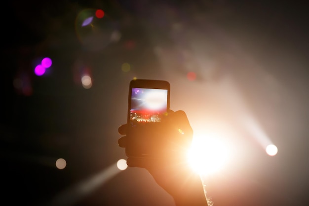 Téléphone portable dans les mains lors d'un spectacle musical Utilisation d'un concept de smartphone