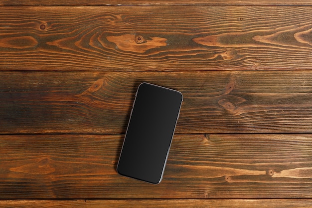 Téléphone portable sur une table en bois