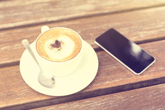 Téléphone portable et tasse de café sur la table