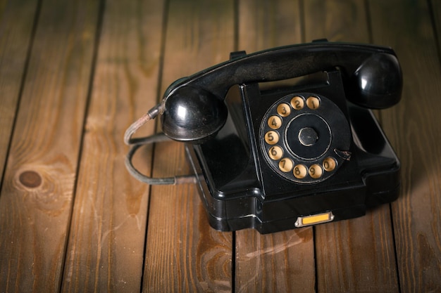 Téléphone rétro noir sur fond de bois