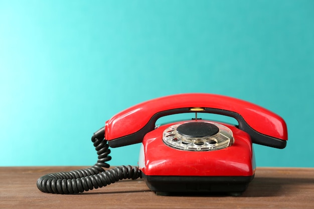 Téléphone rouge rétro sur table sur fond vert