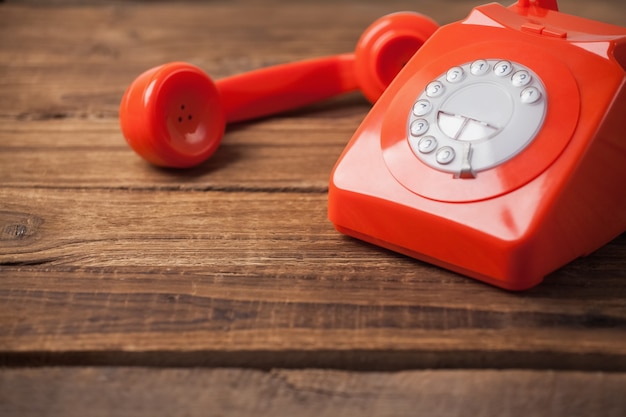 Téléphone rouge sur la table en bois