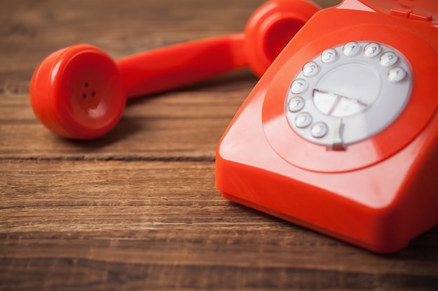 Téléphone rouge sur la table en bois