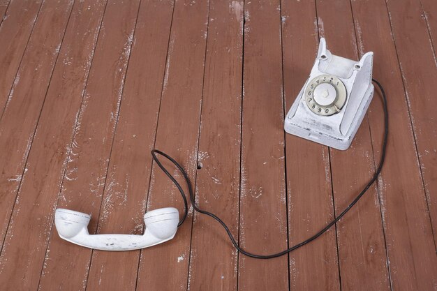 Téléphone vintage blanc avec le ramassé sur un bois brun texturé