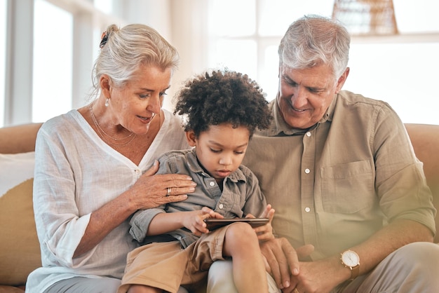 Téléphoner aux grands-parents et à l'enfant à la maison heureux et se lier dans le salon Smartphone enfant interracial et grand-père et grand-mère dans le salon en streaming film vidéo ou film Internet sur les réseaux sociaux