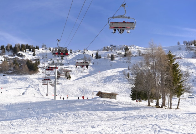 Téléski sous ciel bleu et au dessus de la piste de ski