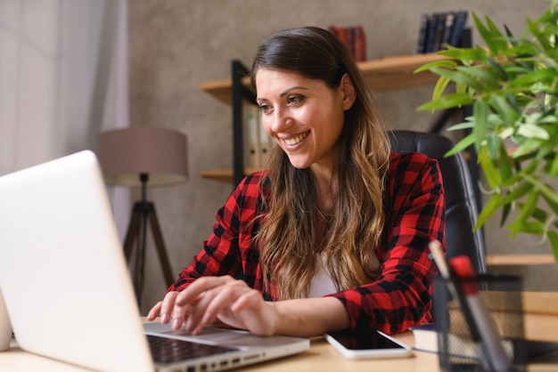 Télétravailleur femme travaille à la maison avec un ordinateur portable