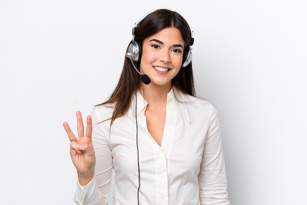 Télévendeur femme caucasienne travaillant avec un casque isolé sur fond blanc heureux et comptant trois avec les doigts