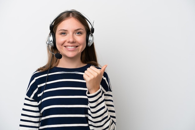 Télévendeur femme caucasienne travaillant avec un casque isolé sur fond blanc pointant vers le côté pour présenter un produit