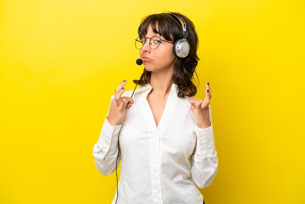 Télévendeur femme latine travaillant avec un casque isolé sur fond jaune