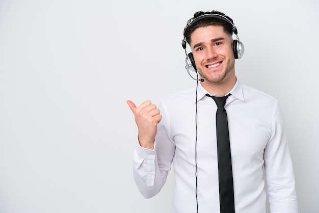 Télévendeur homme caucasien isolé sur fond blanc pointant vers le côté pour présenter un produit