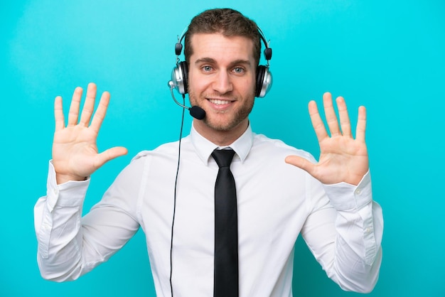 Télévendeur homme caucasien travaillant avec un casque isolé sur fond bleu comptant dix avec les doigts