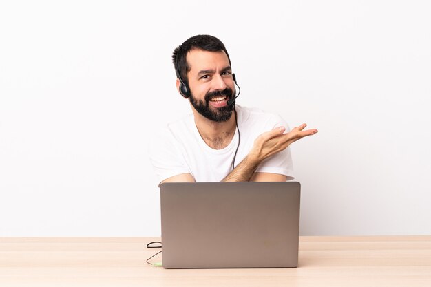 Télévendeur homme caucasien travaillant avec un casque et avec un ordinateur portable présentant une idée tout en regardant vers