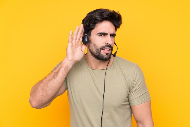 Télévendeur homme travaillant avec un casque sur un mur isolé