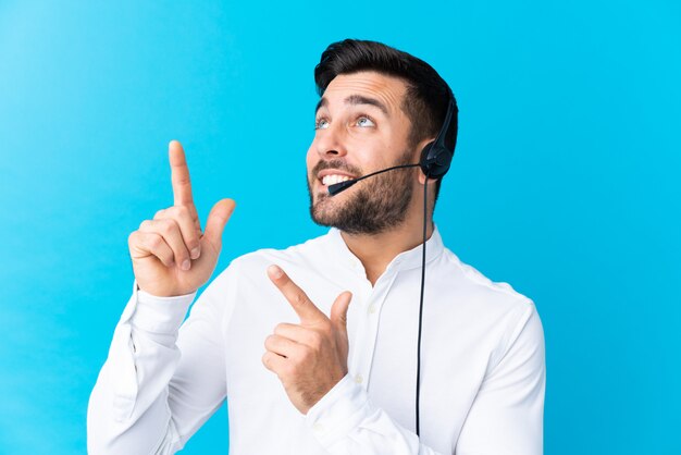 Télévendeur homme travaillant avec un casque sur un mur isolé