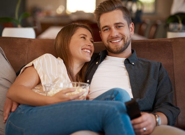 La télévision est la forme de divertissement la plus courante et la meilleure Photo recadrée d'un jeune couple se relaxant avec du pop-corn sur le canapé à la maison
