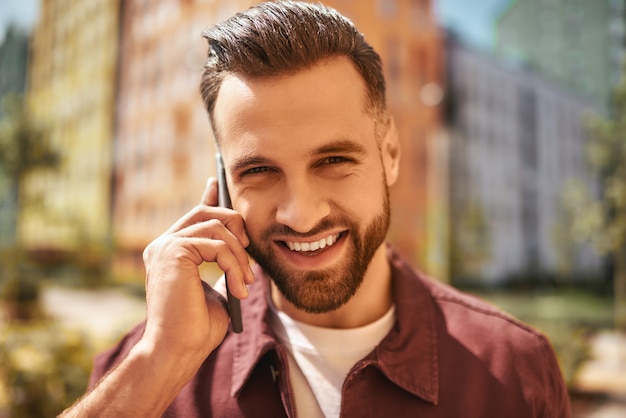 Tellement bon de vous entendre portrait d'homme barbu gai et beau parler par téléphone