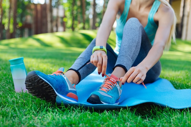 Tellement confortable. Gros plan de nouvelles chaussures de sport bleu portées par une belle coupe de jeunes femmes