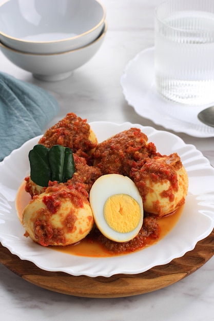 Telur Balado ou ufs à la coque avec sauce chili piquante et épicée. Servi sur plaque blanche