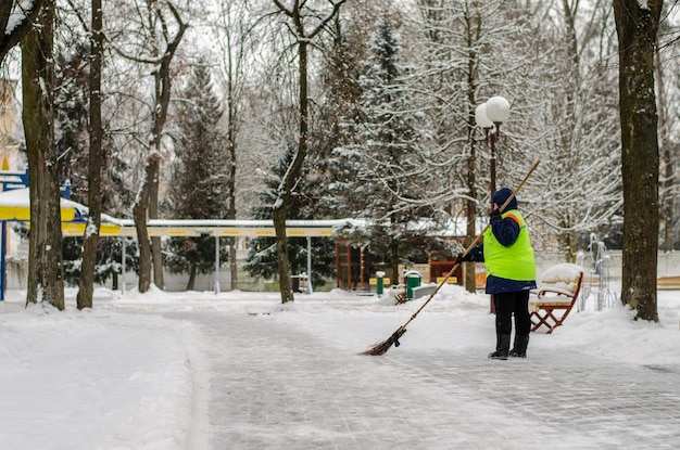 Tempête de neige dans la ville Routes et trottoirs recouverts de neige Une pelle de travailleur dégage la neige Mauvais temps hivernal Nettoyage des rues après une tempête de neige