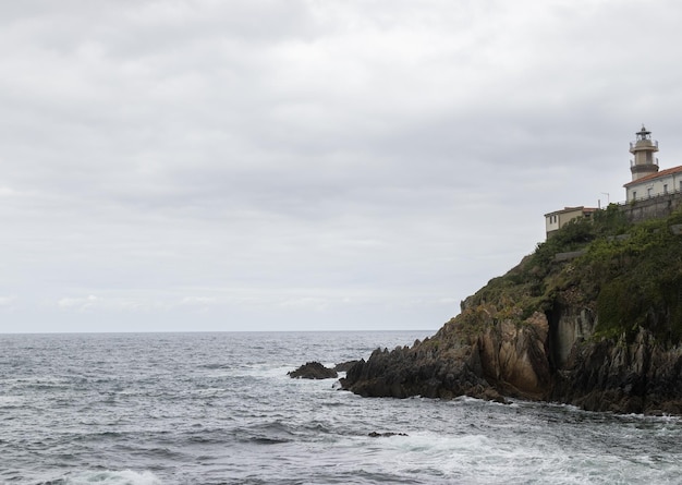 Tempête vue de la côte, phare à droite