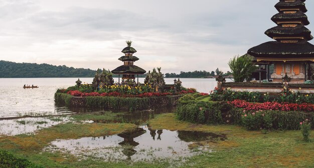 Photo temple au bord du lac et bâtiment contre le ciel