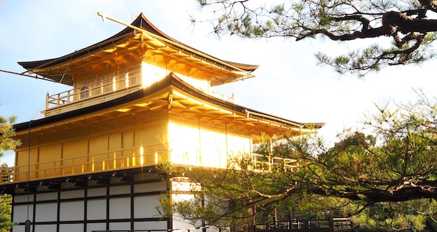 Le temple d'or ou Kinkakuji à Kyoto au Japon tire de l'arrière et a un flou évasé de la vraie lumière du soleil à partir d'un matériau doré.