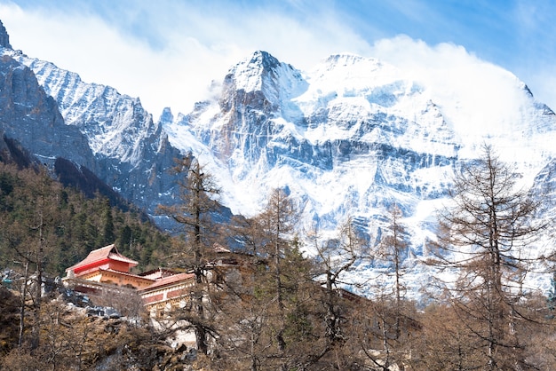 Temple tibétain sur la montagne de neige avec des roches grises