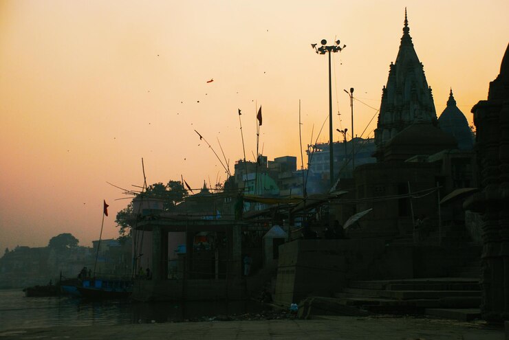 Photo des temples au bord de la rivière ganges contre le ciel au coucher du soleil