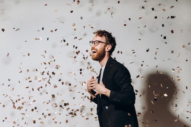 Temps de célébration Portrait d'un mec heureux dansant sous des confettis scintillants