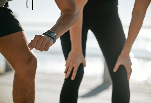 Temps de couple en cours d'exécution et montre intelligente avec fitness et vérification de la fréquence cardiaque avec cardio et entraînement en plein air Jambes mains et cardiologie avec coureur noir homme et femme exercice et bien-être avec pause de course