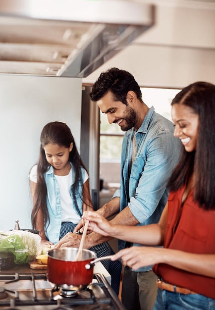 Le temps de cuisiner le temps de créer des liens Photo d'une jeune famille heureuse préparant un repas dans la cuisine ensemble à la maison