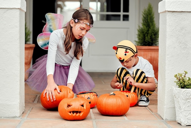 Des temps effrayants sont en route Photo de deux adorables jeunes frères et sœurs jouant ensemble à l'Halloween à la maison