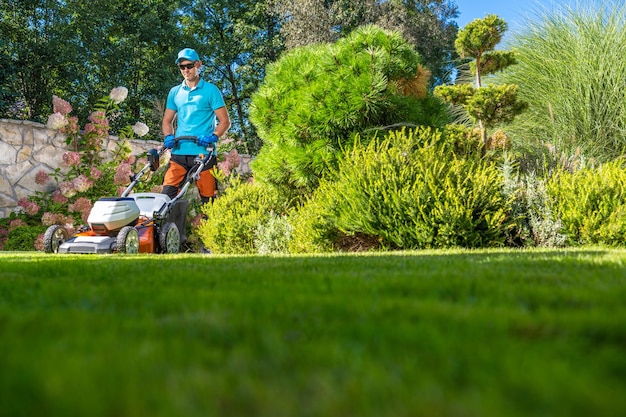 Photo temps d'été couper l'herbe dans le jardin de la cour par le propriétaire de la maison caucasienne thème de jardinage